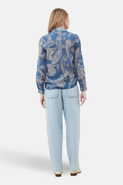 Chemise à manches longues bleue de CAROLL, à motif cachemire, portée avec un jean ample bleu clair.