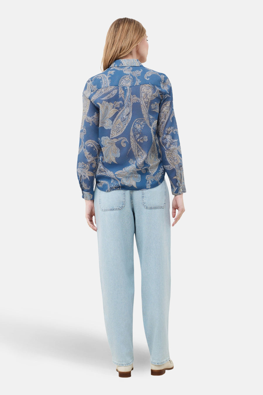 Chemise à manches longues bleue de CAROLL, à motif cachemire, portée avec un jean ample bleu clair.