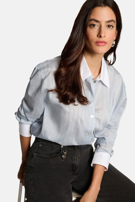 Chemise à manches longues bleue à rayures, de Morgan de Toi, avec boutons et col blancs, portée avec un jean noir.
