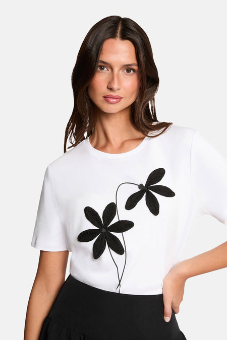T-shirt blanc à manches courtes de Morgan de Toi orné de fleurs noires décoratives sur le devant.