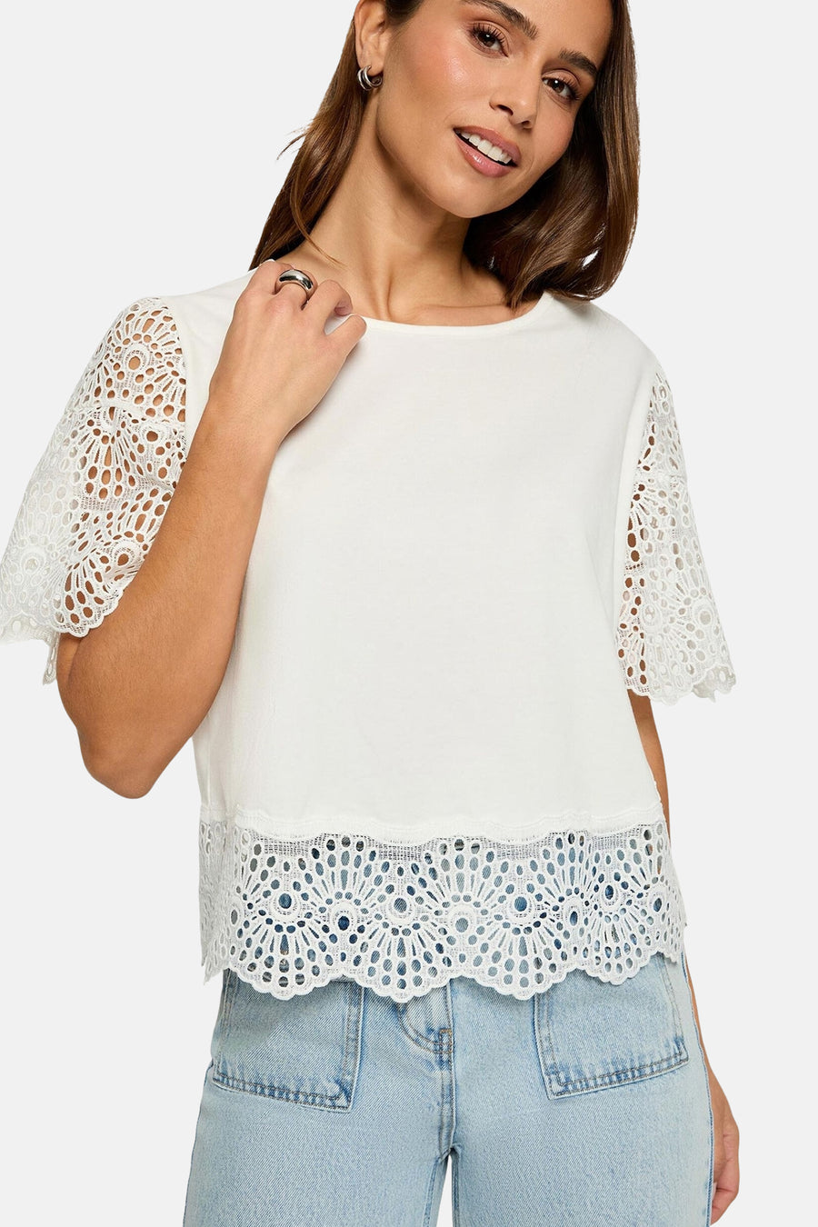 T-shirt blanc de Morgan de Toi avec manches courtes en dentelle et bordure festonnée, porté avec un jean bleu clair.

