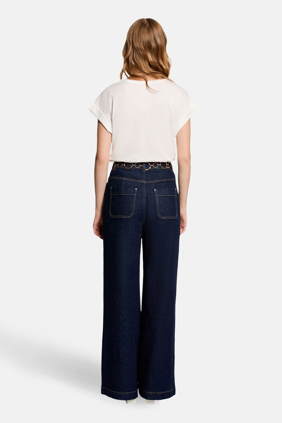 T-shirt à manches courtes blanc de Morgan de Toi, associé à un jean taille haute et une ceinture à anneaux.