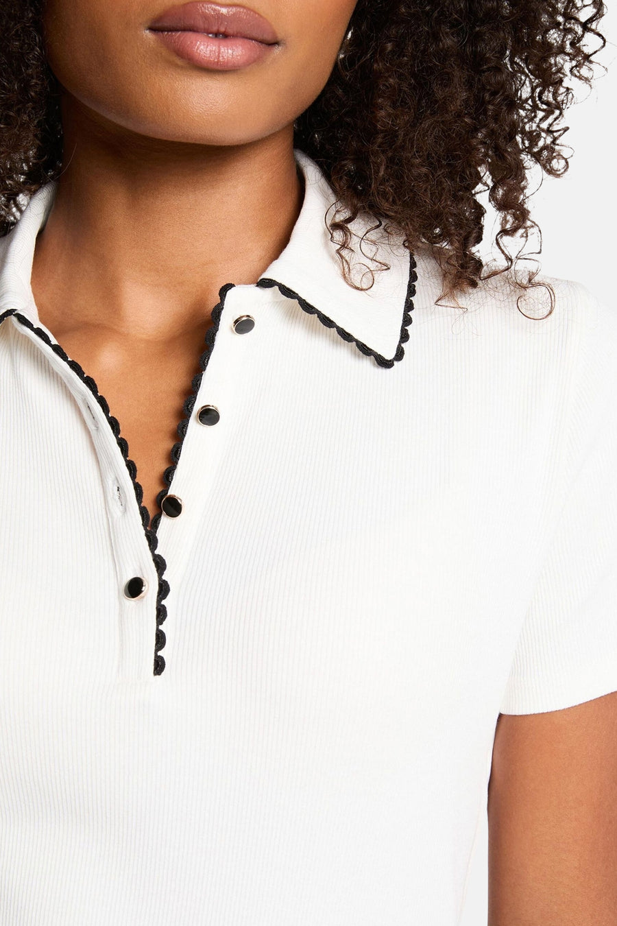 Wit poloshirt met korte mouwen van Morgan de Toi met gouden knopen en zwarte geschulpte rand.