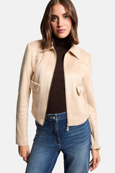 Veste courte beige de Morgan de Toi avec poches à rabat et fermeture éclair sur un pull col roulé marron.
