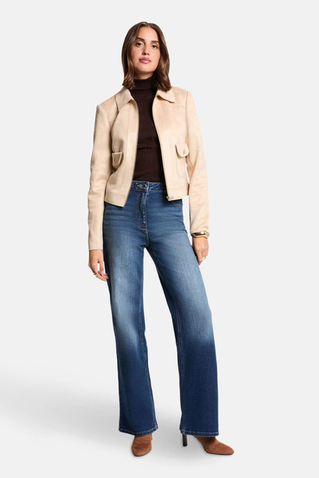 Veste courte beige de Morgan de Toi avec poches plaquées, portée sur un col roulé marron et un jean taille haute.