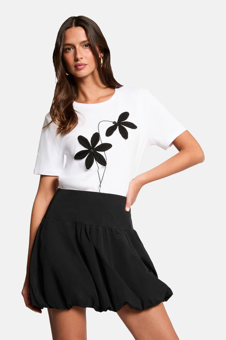 Jupe courte noire de Morgan de Toi avec une coupe ballon et une texture lisse.