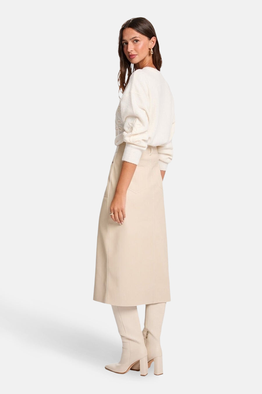 Jupe 3/4 beige de Morgan de Toi, coupe droite, portée avec un pull blanc et des bottes assorties.