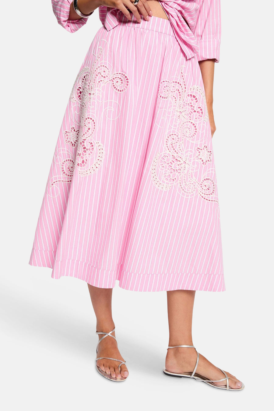 Roze 3/4 rok met witte verticale strepen van Morgan de Toi, van achteren gedragen met bijpassend overhemd, oorringen en zilveren sandalen.