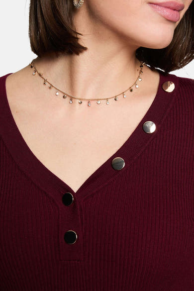 Burgundy ribbed V-neck sweater with metallic buttons, close-up front view, model wearing delicate chain necklace