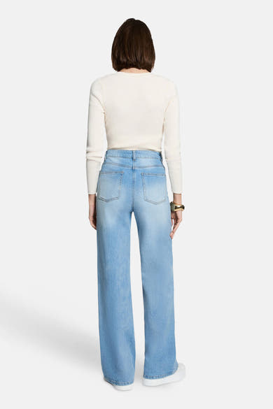 Ecru ribbed V-neck sweater back view with long sleeves, worn with light blue wide-leg jeans and white sneakers.