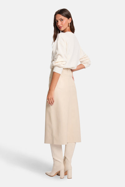 Pull à col rond écru de Morgan de Toi, porté avec une jupe beige et des bottes assorties.