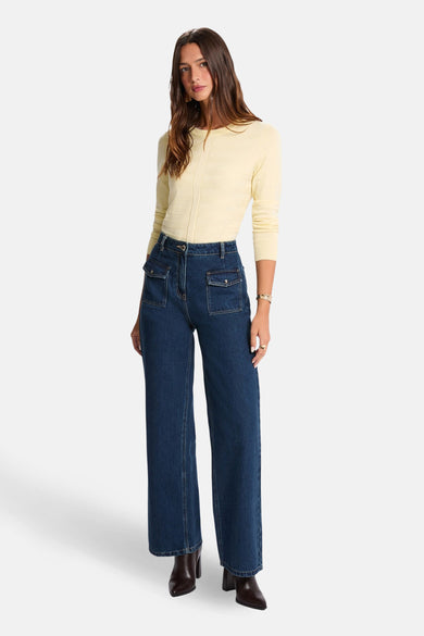 Gele rondehals trui van Morgan de Toi, gedragen met een donkere broek en enkellaarsjes.