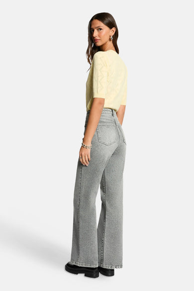 Pull jaune à col rond et manches courtes de Morgan de Toi à motifs ajourés, vu de dos avec un jean gris.
