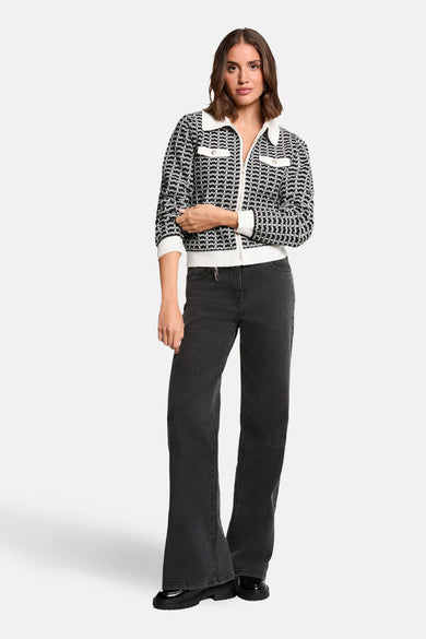 Zwarte jacquard gebreide cardigan van Morgan de Toi, met witte geribbelde kraag en afwerkingen, gedragen met een zwarte jeans.