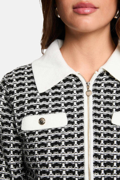 Zwarte gebreide cardigan van Morgan de Toi met gouden ritssluiting en witte kraag.