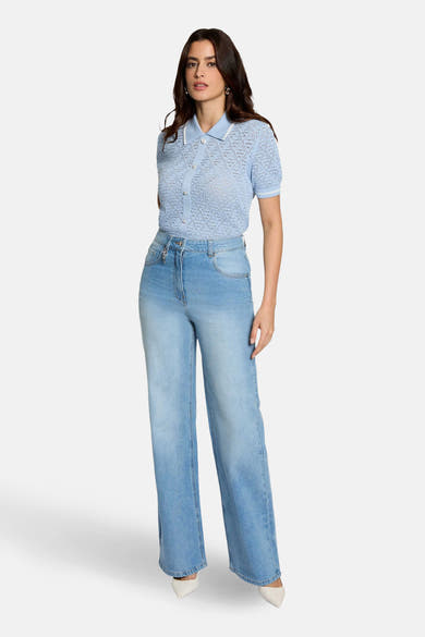 Pull bleu de Morgan de Toi, à maille ajourée, porté avec un jean taille haute et des escarpins.
