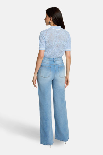 Pull bleu de Morgan de Toi avec motif ajouré, porté avec un jean taille haute.

