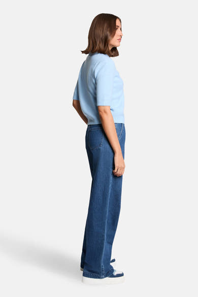 Pull bleu de Morgan de Toi, manches courtes, porté avec un jean ample et des baskets à plateforme, vue de côté.