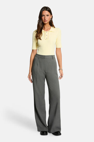 Polo jaune en maille côtelée de Morgan de Toi, orné de boutons et porté avec un pantalon gris.
