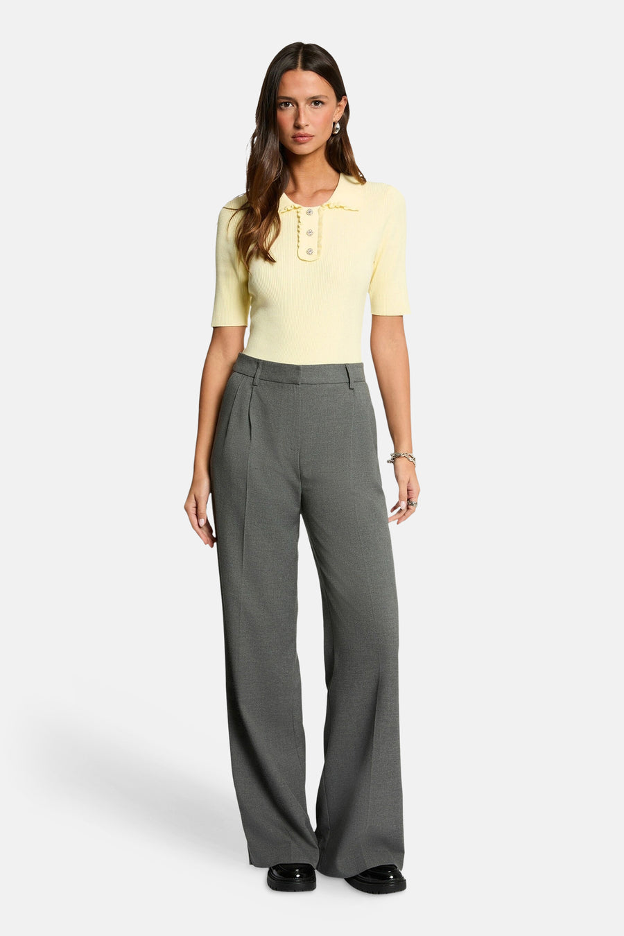 Polo jaune en maille côtelée de Morgan de Toi, orné de boutons et porté avec un pantalon gris.
