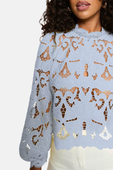 Blouse à manches longues bleue de Morgan de Toi avec détails en dentelle ajourée et col montant.