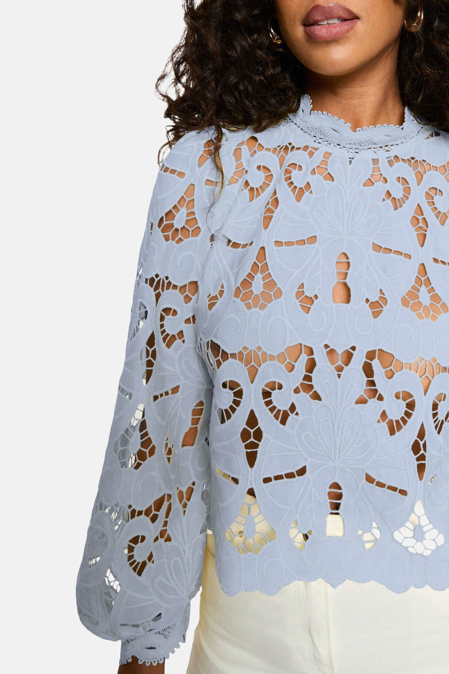 Blouse à manches longues bleue de Morgan de Toi avec détails en dentelle ajourée et col montant.