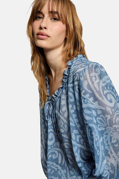 Blouse bleue de Morgan de Toi, à motif paisley délicat, avec un col à volants et des manches longues.
