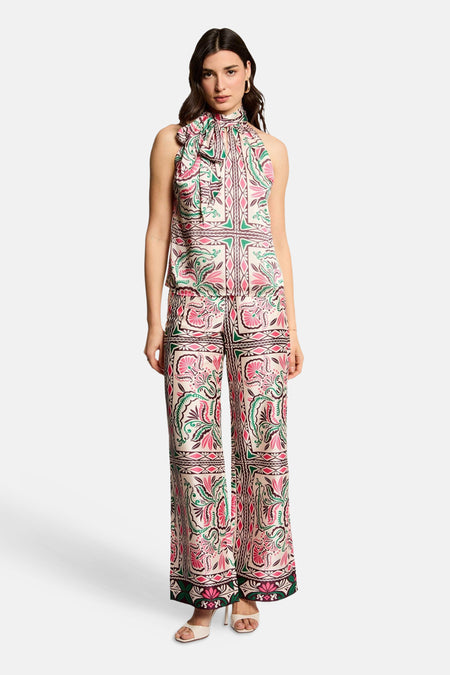 Pantalon multicolore de Morgan de Toi à motif floral et géométrique, porté avec un haut assorti et des sandales.