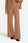 Pantalon de costume brun de Morgan de Toi, coupe évasée et chaussures noires portées avec.