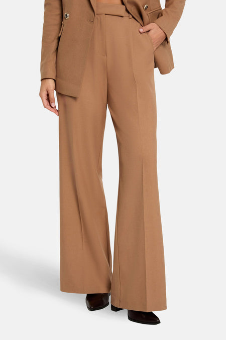 Pantalon de costume brun de Morgan de Toi, coupe évasée et chaussures noires portées avec.