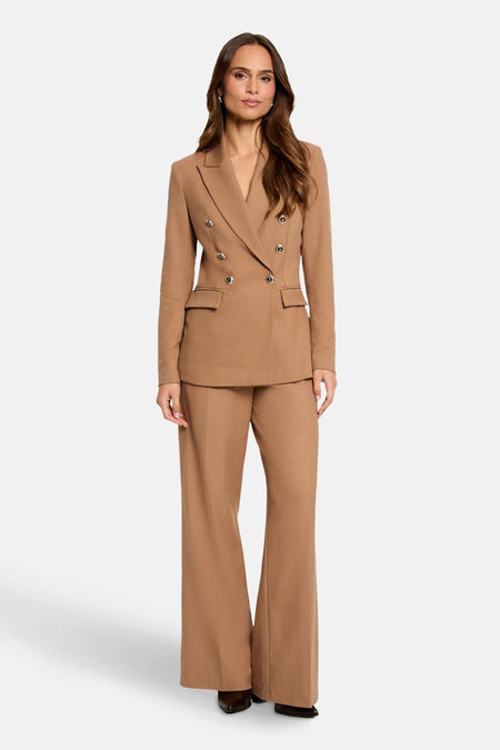 Pantalon de costume brun par Morgan de Toi, coupe évasée et porté avec un blazer assorti.