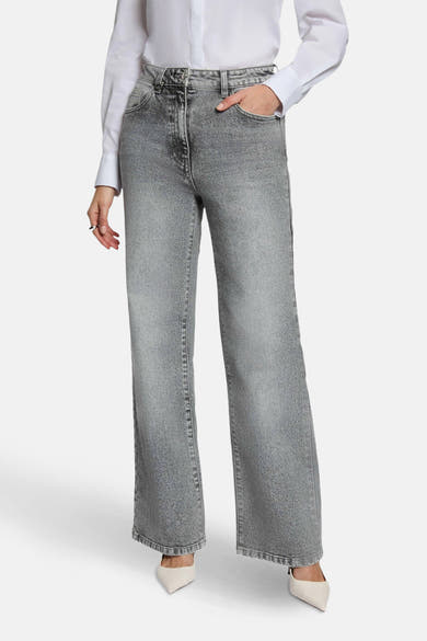 Jean large gris moyen de Morgan de Toi, porté avec une chemise blanche et des escarpins ivoire.