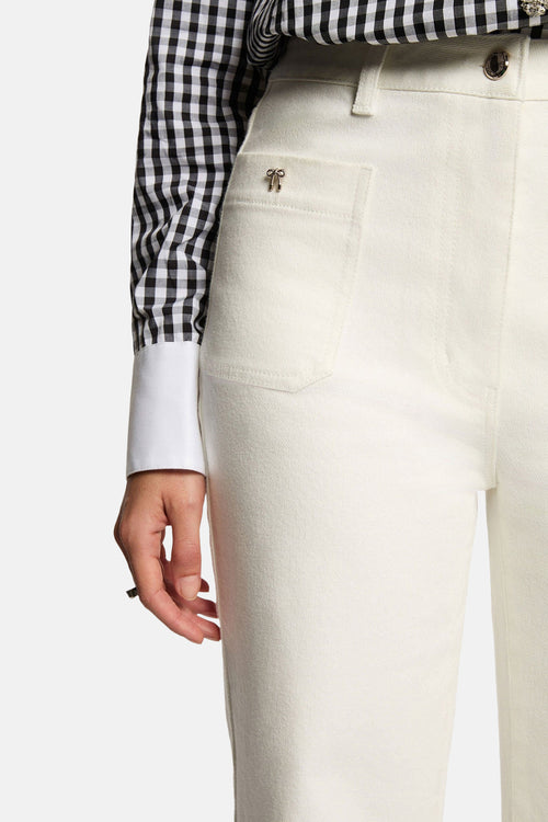 Jean coloré blanc de Morgan de Toi avec une petite poche avant ornée d'un nœud, porté avec une chemise à carreaux.
