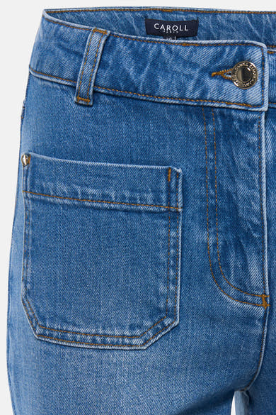 Jean large en denim bleu moyen de Caroll, avec poche plaquée et détails de couture ocre.