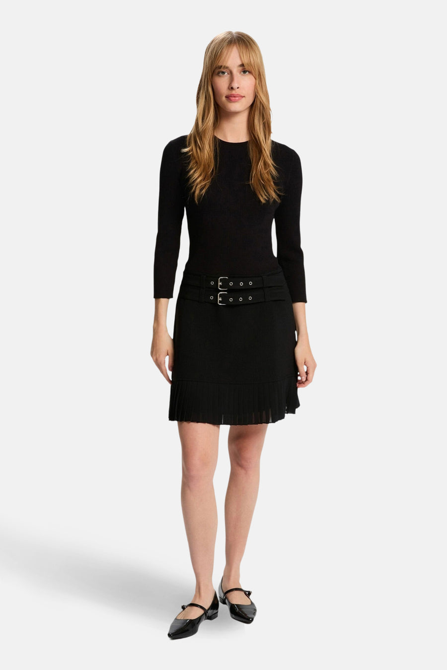 Robe noire 3/4 de Morgan de Toi avec ceinture à boucle et jupe plissée, portée avec des chaussures noires.
