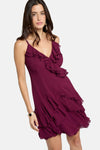 Robe bordeaux de Morgan de Toi avec volants, bretelles fines et bracelet doré.