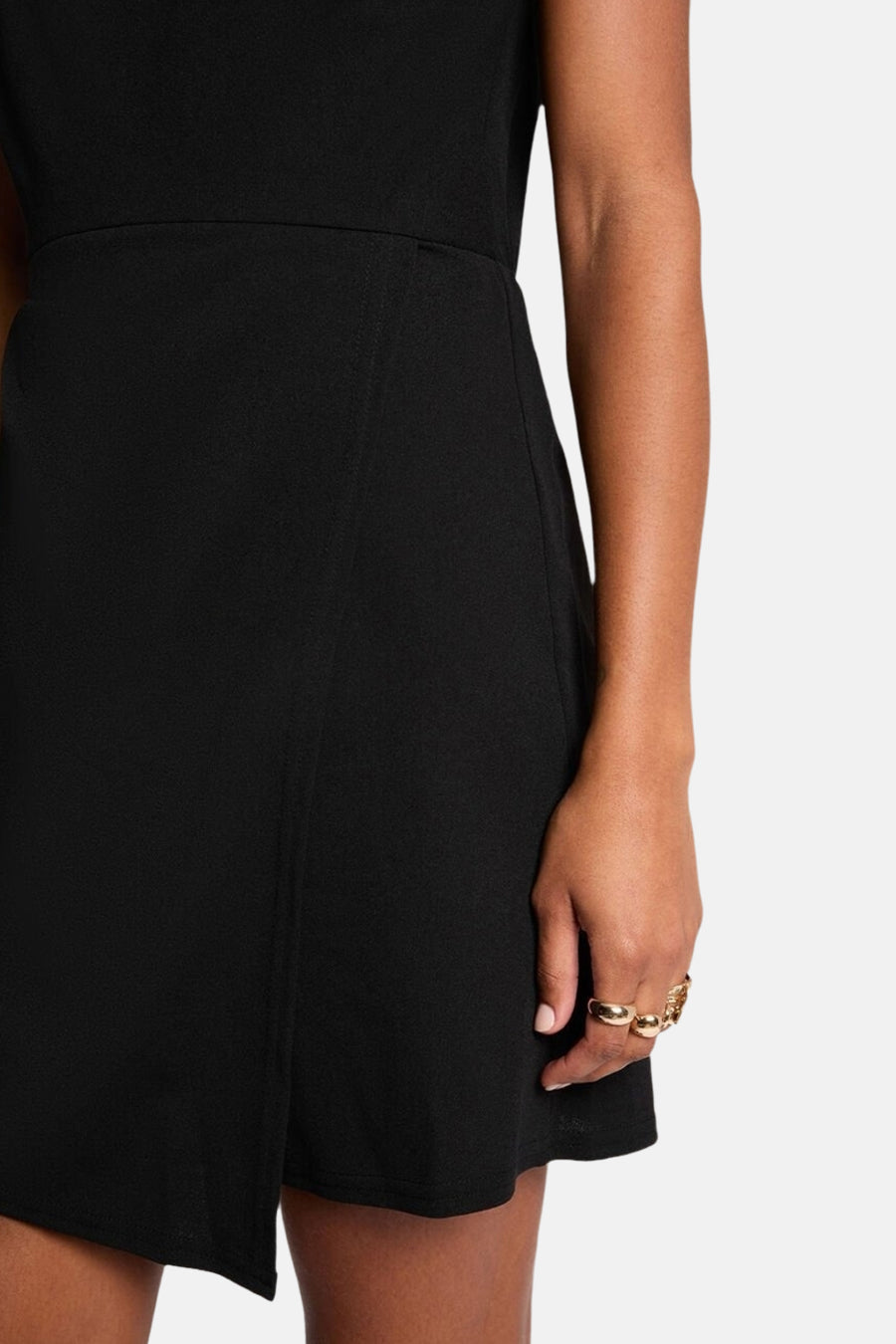 Robe noire de Morgan de Toi, coupe asymétrique et drapée, accessoirisée de bagues dorées.