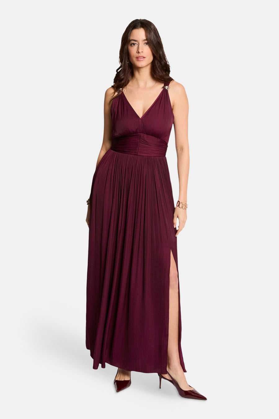 Robe bordeaux par Morgan de Toi, coupe longue avec une fente et des bretelles dorées.