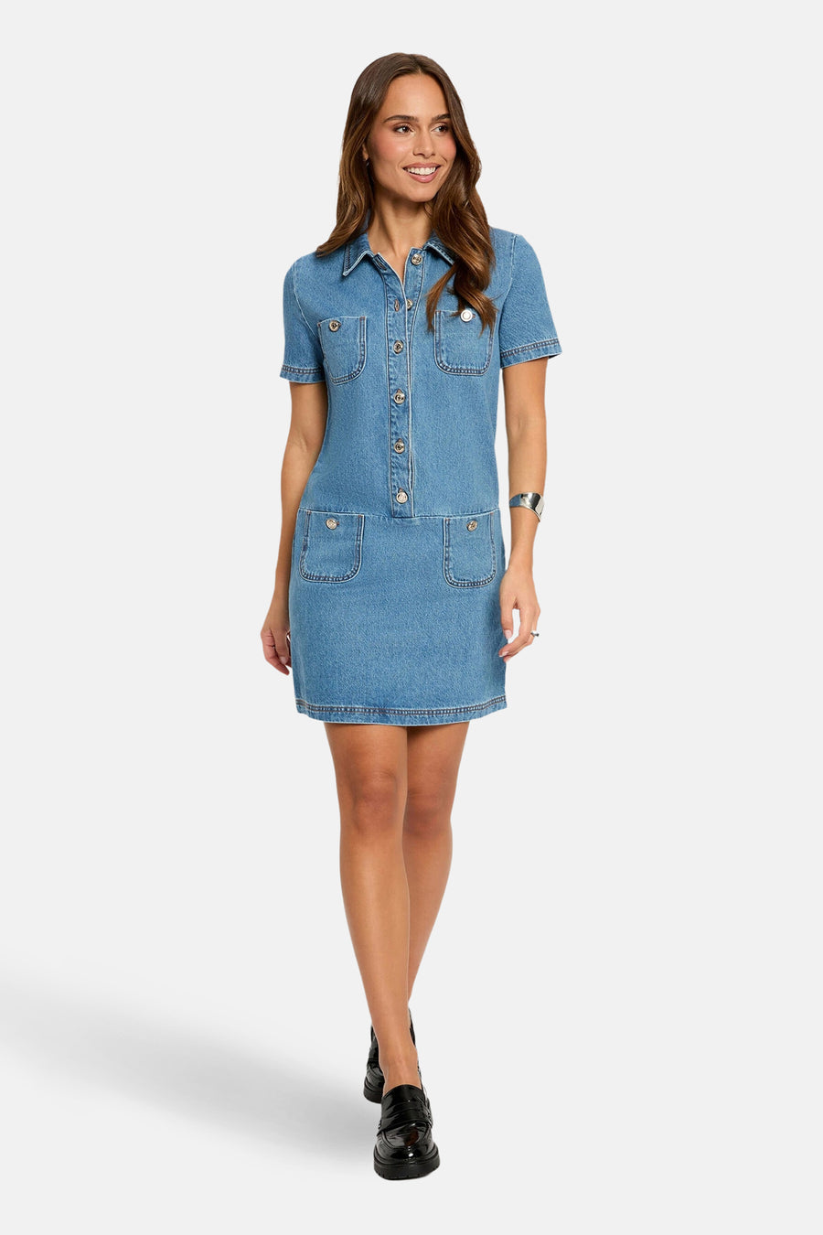 Robe en denim bleu moyen de Morgan de Toi avec des poches plaquées et des boutons décoratifs, portée avec des chaussures noires.
