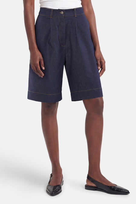 Short Bermuda en jean bleu foncé de Morgan de Toi, taille haute à plis, avec surpiqûres contrastantes.