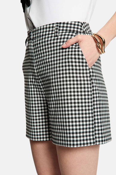 Short noir à carreaux vichy de Morgan de Toi, avec une main dans la poche et un bracelet doré.
