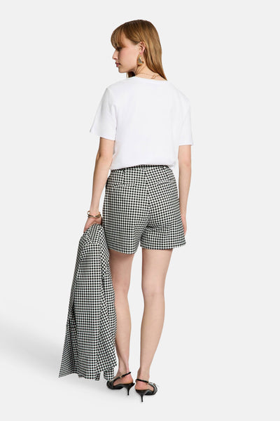 Short noir à carreaux, de Morgan de Toi, porté avec un t-shirt blanc et des chaussures noires à talons.