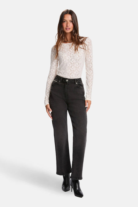 T-shirt à manches longues écru de Morgan de Toi en dentelle florale, porté avec un jean noir taille haute et des bottines noires.
