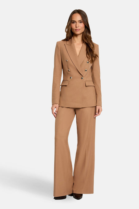 Bruine blazer van Morgan de Toi, dubbelgeknoopt met decoratieve knopen en klepzakken, gedragen met een bijpassende broek.