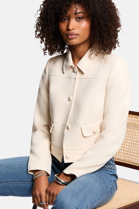 Veste courte écru de Morgan de Toi avec boutons et poches, portée avec un jean bleu.
