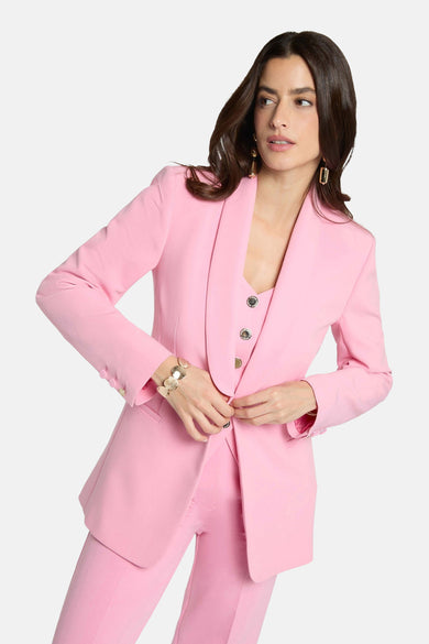 Blazer rose de Morgan de Toi, porté par une femme avec des boucles d'oreilles dorées et un bracelet orné.
