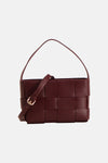 Red woven leather handbag with top handle and adjustable strap, front view