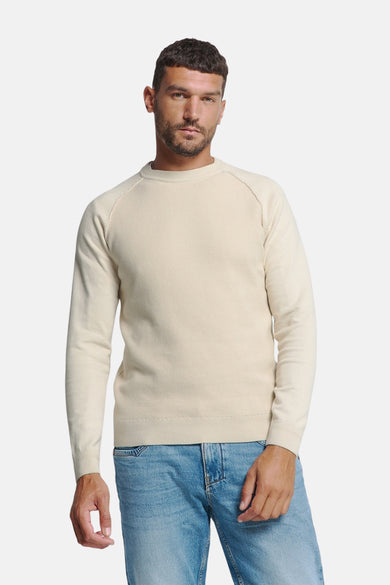 Pull écru à col rond de NO EXCESS, en maille côtelée, porté avec un jean bleu clair.