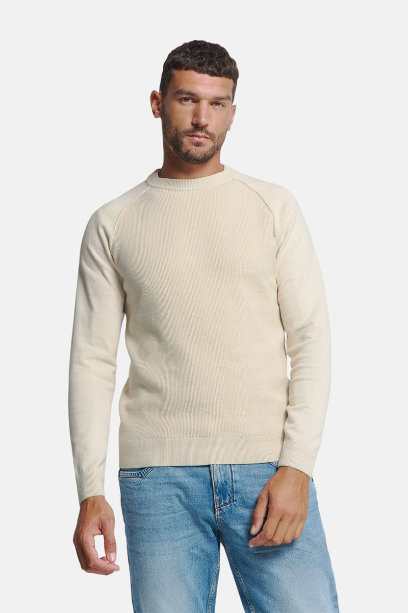 Pull écru à col rond de NO EXCESS, en maille côtelée, porté avec un jean bleu clair.