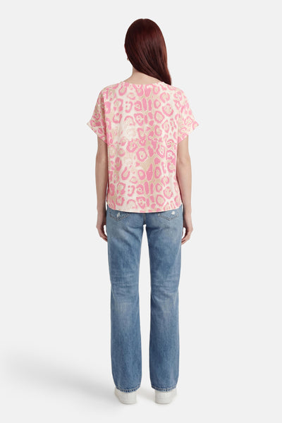 T-shirt rose à imprimé léopard, de Terra di Siena, porté avec un jean et des baskets blanches, vue de dos.
